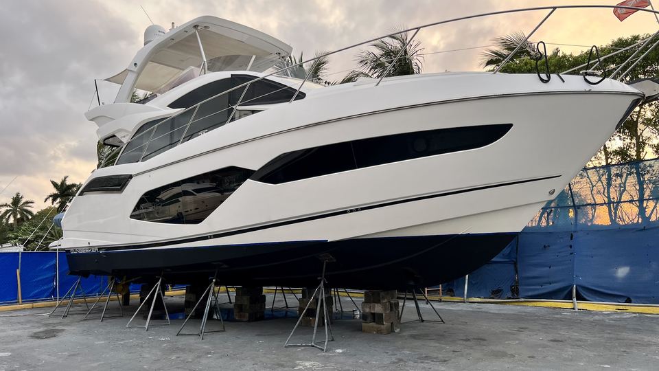 Flybridge yacht blocked on jack stands in the boatyard at sunset